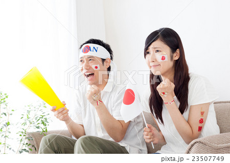 スポーツのテレビ観戦 女性 男性 2ショット 手に汗握る ピンチの写真素材