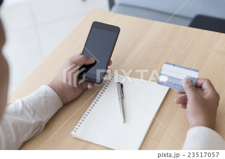 businessman's hand with mobile phone, credit card 23517057