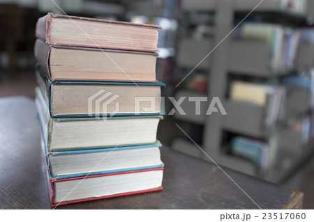 old book on wooden table with blur library  23517060