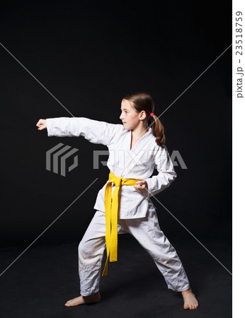Child girl in karate suit with yellow belt show 23518759