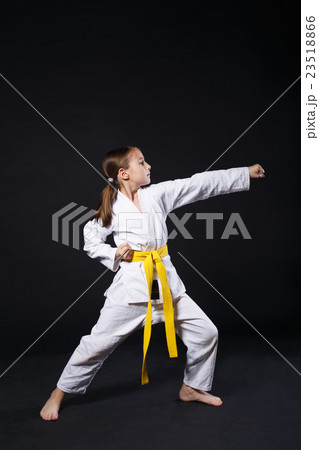 Child girl in karate suit with yellow belt show 23518866