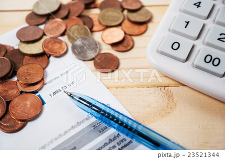Bill with coins and pen and calculator on table Bill with coins and pen and calculator on table 23521344