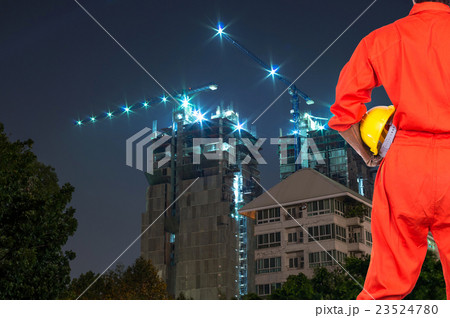 Asian engineers holding a yellow hardhat on construction site building at twilight time, industrial construction concept Asian engineers holding a yellow hardhat on construction site building at twilight time, industrial construction concept 23524780