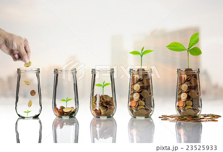 Hand putting Gold coins and seed in clear bottle on cityscape photo blurred cityscape background,Business investment growth concept Hand putting Gold coins and seed in clear bottle on cityscape photo blurred cityscape background,Business investment growth concept 23525933