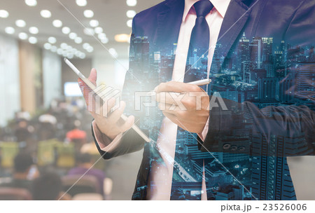 Double exposure of Businessman using the tablet on the Abstract blurred photo of conference hall or seminar room with attendee background Double exposure of Businessman using the tablet on the Abstract blurred photo of conference hall or seminar room with attendee background 23526006