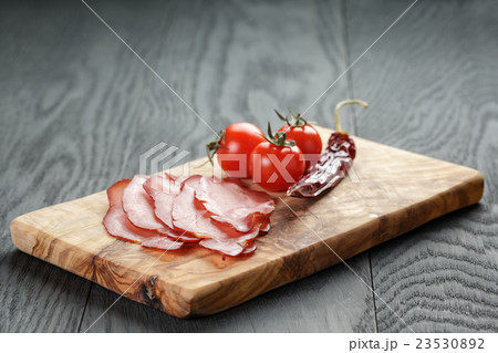 smoked ham prsut with cherry tomatoes and chili 23530892