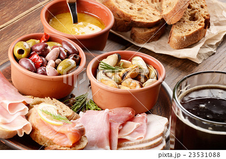 Tapas of salmon mussels jamon and olives with beer 23531088