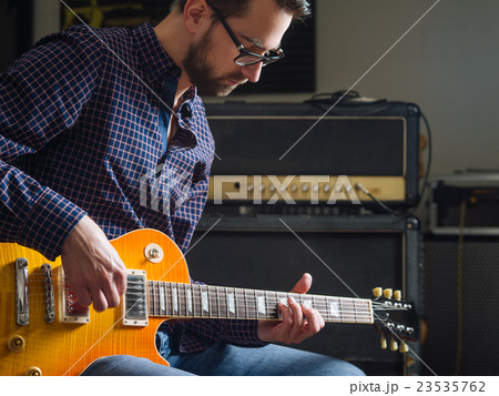 Bearded man playing guitar 23535762