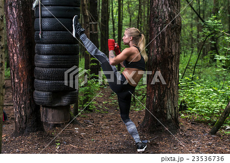 Woman practising kickboxing performing a leg axe 23536736