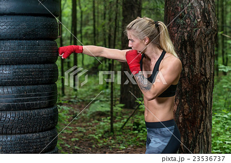 Woman boxer doing cross kick working out outdoors 23536737