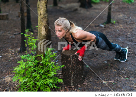 Muscular woman doing push-ups at park street work 23536751