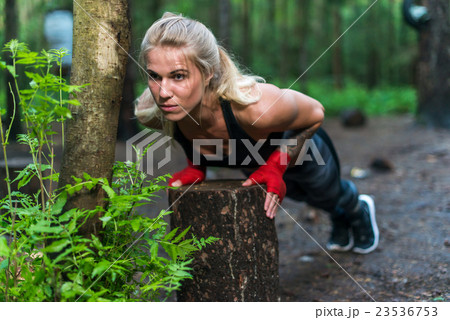 Muscular woman doing push-ups at park street work 23536753