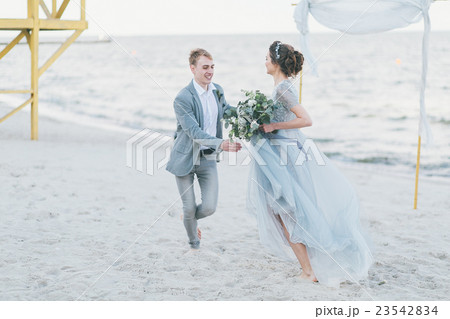Happy newly-weds are having fun and running by the Happy newly-weds are having fun and running by the 23542834