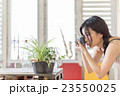 部屋で写真を撮る若く美しい日本人女性 23550025