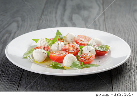 caprese salad with mini mozzarella balls 23551017