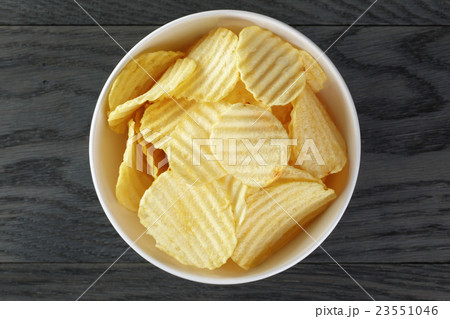 rippled organic chips in white bowl on wooden 23551046
