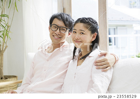 ソファーで寄り添う若い夫婦 23558529