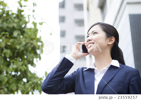 電話をする若い女性 屋外ビジネスイメージ 電話をする若い女性 屋外ビジネスイメージ 23559257