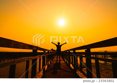 Happy free man silhouette on wooden bridge Happy free man silhouette on wooden bridge 23563802