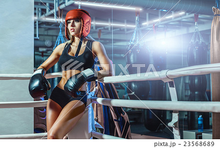 Young pretty boxer woman standing on ring Young pretty boxer woman standing on ring 23568689