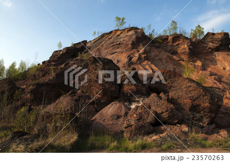 Waste heaps of red rock in industrial district 23570263