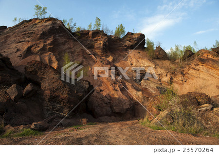 Waste heaps of red rock in industrial district 23570264
