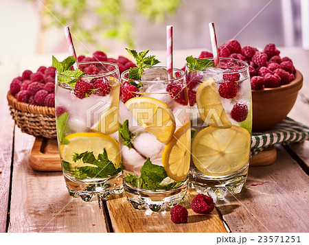 On wooden boards is glasses with mohito and lime. 23571251