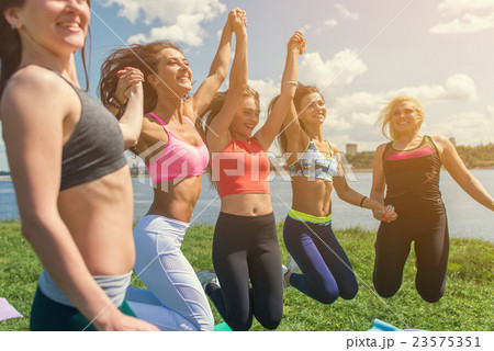 Portrait of young friends having fun jumping on a 23575351