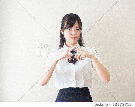 指でバツ印を作る女子高校生の写真素材