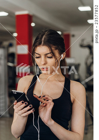 Beautiful girl with a phone in the gym Beautiful girl with a phone in the gym 23577852
