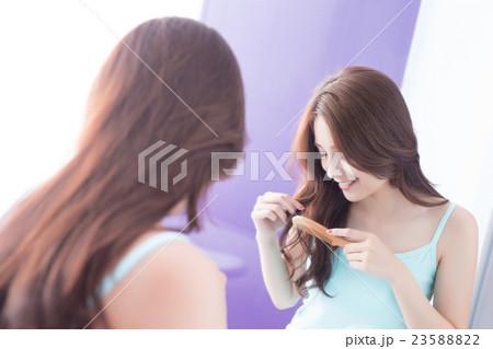 young woman is combing hair young woman is combing hair 23588822