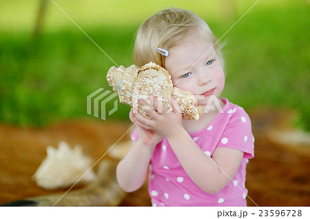 Cute little toddler girl with a shell Cute little toddler girl with a shell 23596728