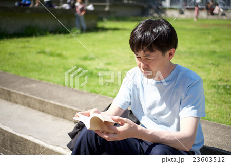 ステップに腰掛け読書をする男性 ステップに腰掛け読書をする男性 23603512