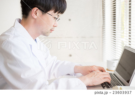 デスクワークをする白衣の男性 23603937
