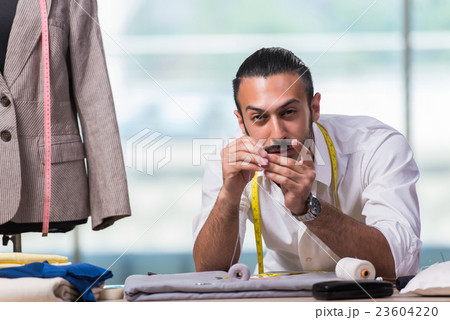 Young tailor working on new clothing design Young tailor working on new clothing design 23604220