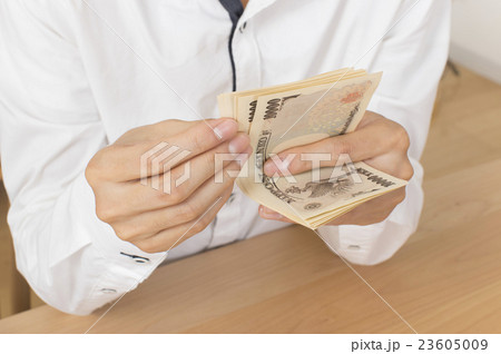 お金を数える男性の手元 23605009
