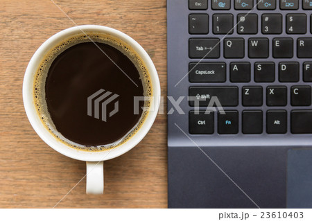 Top view of coffee cup , laptop on wooden table 23610403