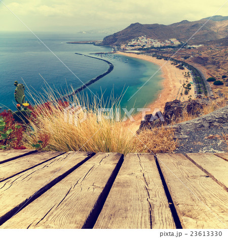Sunset on the beach and empty wooden deck table 23613330