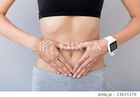 Pleasant woman keeping hands on her belly Pleasant woman keeping hands on her belly 23615370
