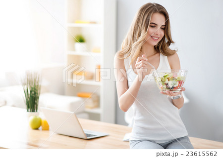 Positive smiling woman eating salad Positive smiling woman eating salad 23615562