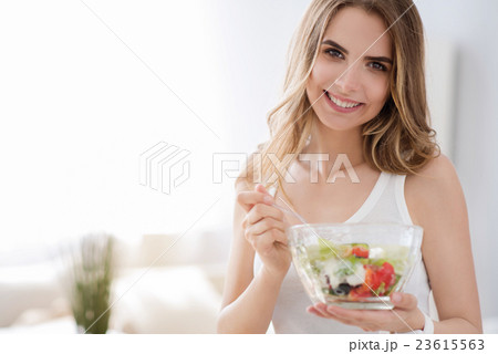 Cheerful woman eating vegetable salad. 23615563