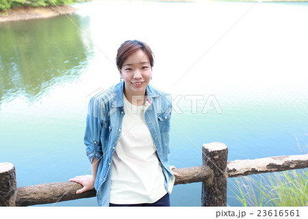 湖を背景に立っている若い日本人女性 23616561