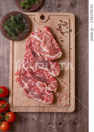 Fresh raw pork chop meat on cutting board Fresh raw pork chop meat on cutting board 23620630