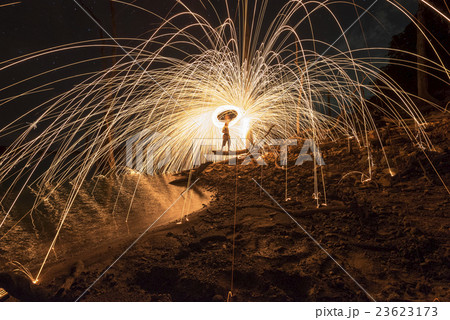 Men cast field Fire steelwool in the night time. 23623173