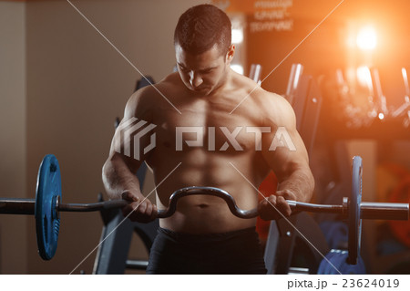 Fitness man exercising with barbell in gym 23624019