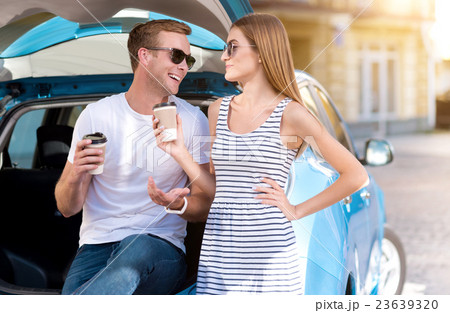 Man and woman drinking coffee on trunk Man and woman drinking coffee on trunk 23639320