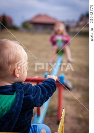 Boy and girl on a swing 23642779