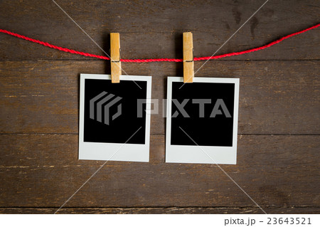 two blank photo frame hanging on wood background 23643521
