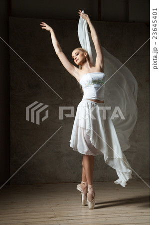 Elegant ballerina dancing in white costume and 23645401