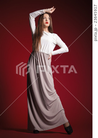 beautiful girl in long dress posing against red beautiful girl in long dress posing against red 23645917